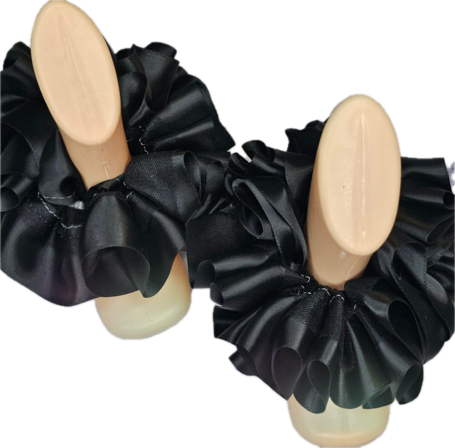 Black single color anklets with elegant ruffled design displayed on mannequin feet